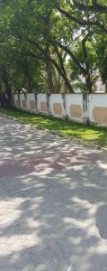 a road with trees and a white fence at ADIA APARTMENTS in Mombasa