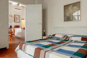 a bedroom with a bed with a colorful blanket on it at Casavacanzepisa in San Giuliano Terme