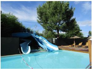 a blue water slide in a swimming pool at Mobilhome rénove climatisé - 10min plage - Mimizan in Mimizan +5 photos