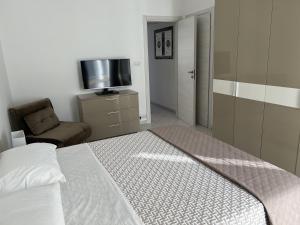 a bedroom with a bed and a tv and a chair at Lingotto35 in Turin