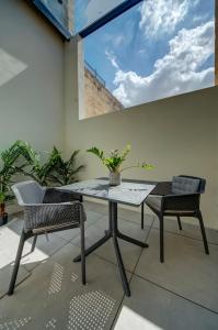 un patio con mesa y 2 sillas en 23 Boutique Hotel, en Floriana