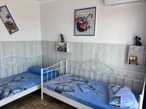 a bedroom with two bunk beds with blue sheets at Flower Breeze in Chebanka