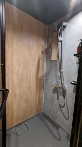 y baño con ducha y pared de madera. en SIDOU 　INN en Onomichi