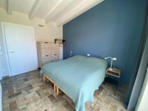 Dormitorio azul con cama y pared azul en Fuoridicampo, en Roncovetro