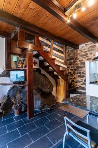 a room with a stone fireplace and a wooden ceiling at Casa de turismo rural Sardom3 in Bembibre