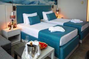 クンドゥにあるCrystal Centro Resort - Ultimate All Inclusiveのベッド2台とテーブルが備わるホテルルームです。