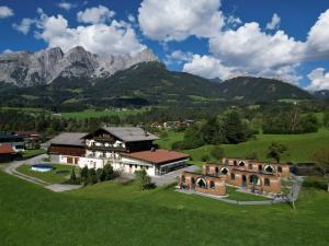 una casa en un campo con montañas en el fondo en Igluhut Four Seasons, en Pfarrwerfen