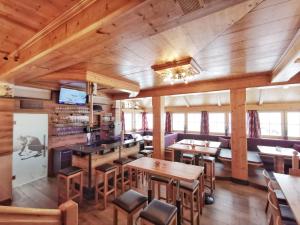 a restaurant with wooden walls and tables and chairs at Aparthotel Bernhof in Obertauern