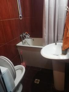 een badkamer met een toilet, een wastafel en een bad bij квартира in Tbilisi City