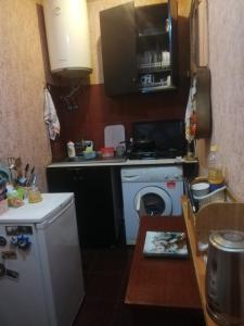 eine Küche mit einem Herd und einer Waschmaschine in der Unterkunft квартира in Tbilisi City