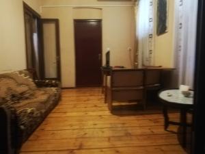 een woonkamer met een bank en een houten vloer bij квартира in Tbilisi City