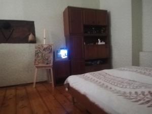 een slaapkamer met een bed en een kleine televisie bij квартира in Tbilisi City