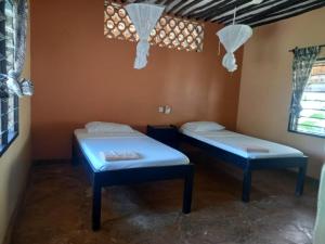 a room with two beds in a room at Malaika Holiday Villas in Diani Beach