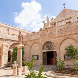 een gebouw met een standbeeld ervoor bij Lovely Lama Family House in Bethlehem