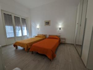 duas camas com lençóis laranja num quarto em Il Centro em Camaiore