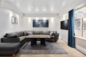 ein Wohnzimmer mit einem Sofa und einem Tisch in der Unterkunft Lyngen View House in Koppangen