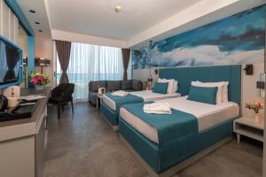 クンドゥにあるCrystal Centro Resort - Ultimate All Inclusiveのベッド2台とデスクが備わるホテルルームです。