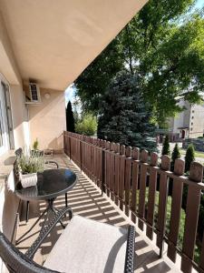 d'une terrasse avec une table, des chaises et une clôture. dans l'établissement Apartament Ponikwoda, à Lublin