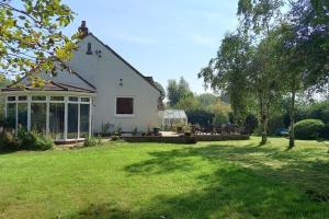 GoxhillにあるMillfields cottage and gardenの芝生の広い庭のある白い家