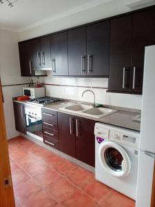 a kitchen with a washing machine and a sink at Lovely y Cozy Apartments in Chulilla