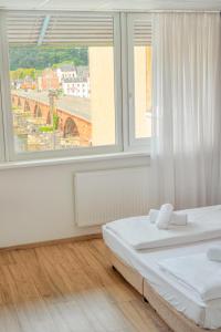 ein Schlafzimmer mit einem Bett und einem großen Fenster in der Unterkunft Hotel Constantin in Trier