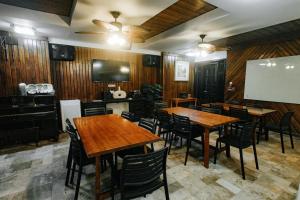 un ristorante con tavoli e sedie in legno e una lavagna bianca di Delle Suites a General Santos