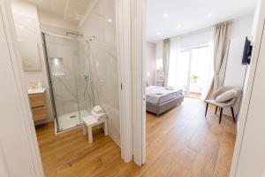 um banheiro com chuveiro e uma cama em um quarto em White Gold em Nápoles