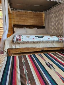a bed in a room with a rug at Jabali Mountain Cabin in Iringa