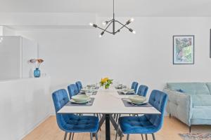 une salle à manger avec une table blanche et des chaises bleues dans l'établissement FiNEST Design Stuttgart Airport Messe Stadtbahn U7, à Ostfildern