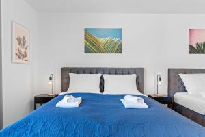 Un dormitorio con dos toallas en una cama azul. en FiNEST Design Stuttgart Airport Messe Stadtbahn U7, en Ostfildern 32 fotos más