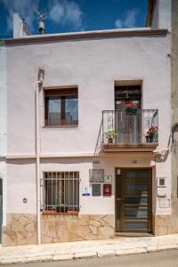 a white building with a balcony and a door at CASA RURAL ANGELITA in Rosell