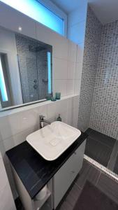 Un baño con un lavabo blanco y un espejo. en Gartenwohnung neben dem LKH, en Graz 1 foto más