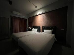 duas camas num quarto de hotel com lençóis brancos em Boonjaras house-บุญจรัส เฮ้าส์ em Amphoe Ban Phu