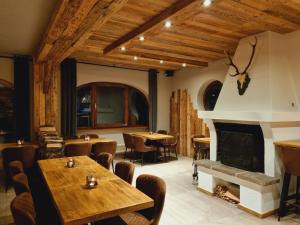 a restaurant with a fireplace and tables and chairs at Hotel Pension Annerlhof in Maria Alm am Steinernen Meer