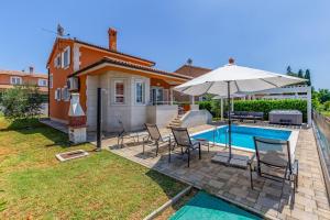 a villa with a swimming pool and an umbrella at Villas Lotus with Pool and Jacuzzi in Pula