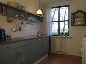 a kitchen with a sink and a window at Erve het Otman in Denekamp