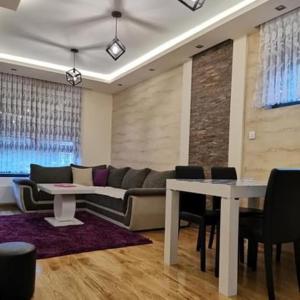 a living room with a couch and a table and chairs at Apartmani Iskra in Zlatibor
