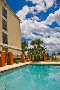una piscina en un hotel con sillas y un edificio en Holiday Inn Express Hotel & Suites Lake Placid, an IHG Hotel, en Lake Placid