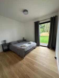 ein Schlafzimmer mit einem Bett und einem großen Fenster in der Unterkunft Maison Villa à proximité du zoo de Thoiry in Arnouville-lès-Mantes