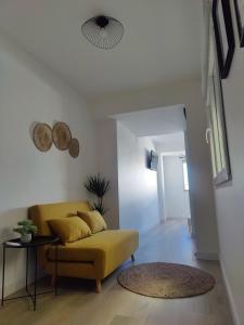 Una sala de estar con un sofá amarillo y una mesa. en O Lar da Muralla, en Lugo 1 foto más