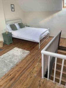 a bedroom with a bed and a wooden floor at Character Cottage Nr Betws Y Coed. in Betws-y-coed