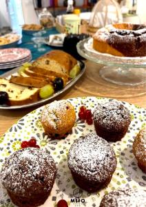 einen Tisch mit Teller mit Donuts und anderen Desserts in der Unterkunft MIIO HOTEL in San Vincenzo