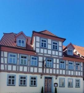 un grand bâtiment avec des fenêtres bleues et un toit dans l'établissement Gasthaus "Garni" Am Viehmarkt, 