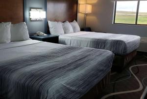 pokój hotelowy z 2 łóżkami i oknem w obiekcie AmericInn by Wyndham Mauston w mieście Mauston