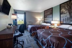 a hotel room with two beds and a desk at Super 8 by Wyndham Mattoon in Mattoon