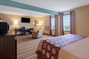 a hotel room with a bed and a desk at Super 8 by Wyndham Mattoon in Mattoon