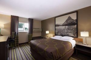 a hotel room with a bed and a desk at Super 8 by Wyndham Belgrade/Bozeman Airport in Belgrade