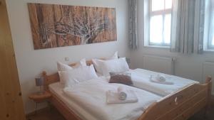 a large white bed with towels on top of it at Gasthaus "Garni" Am Viehmarkt 