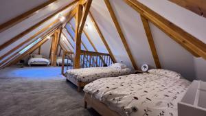a bedroom with two beds in a attic at Complexul Turistic Căsuțele din grădină: Căsuța cu Stuf in Marga