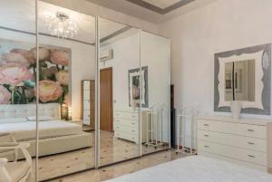 ein Schlafzimmer mit einem großen Spiegel und einem Bett in der Unterkunft Appartamento Angelo bianco in Peschiera del Garda